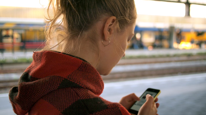 通勤電車でスマートフォンを操作している人のイメージ